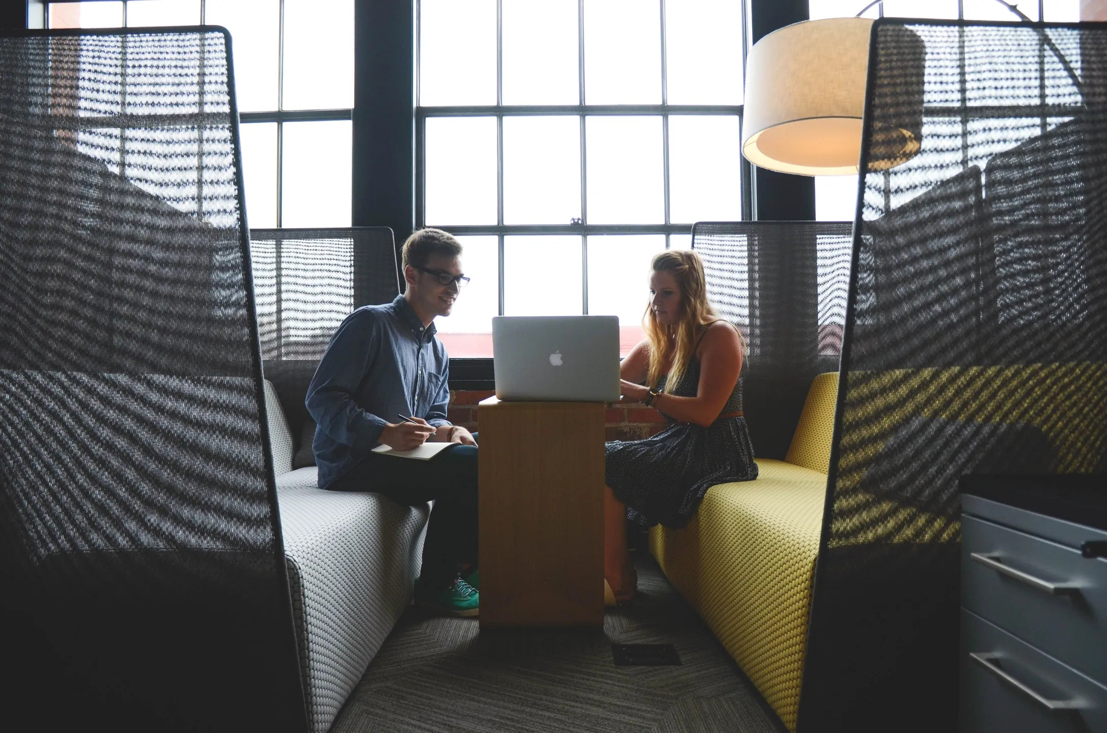 image of two people meeting in building space with large windows