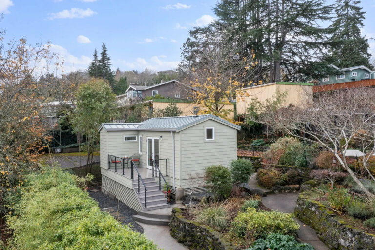 seward park ADU with painted green wood siding and a small exterior porch.